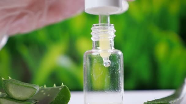 Laboratorio lavoratore apre bottiglia di vetro cadere succo di aloe — Video Stock