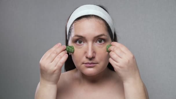 Woman makes facial massage using juice of cut aloe leaves — Stockvideo