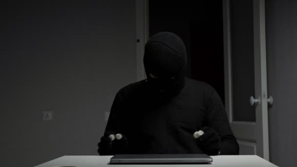 Włamywacz kradnie pieniądze z laptopa i biżuterię siedząc przy biurku. — Wideo stockowe