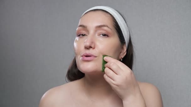 Kvinna gör ansiktsmassage med hjälp av juice av skurna aloe blad — Stockvideo