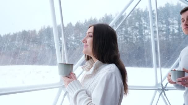 Ο άνθρωπος κατοικίδια ζώα γυναίκα στον ώμο απολαμβάνοντας ποτό στο σπίτι το χειμώνα — Αρχείο Βίντεο