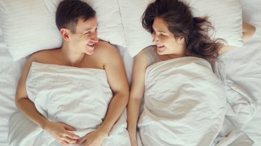 Genç çift yatakta yattıktan sonra iletişim kuruyor.