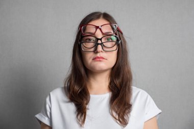 Kadın görüş bozukluğunu gidermek için birkaç gözlük takıyor.