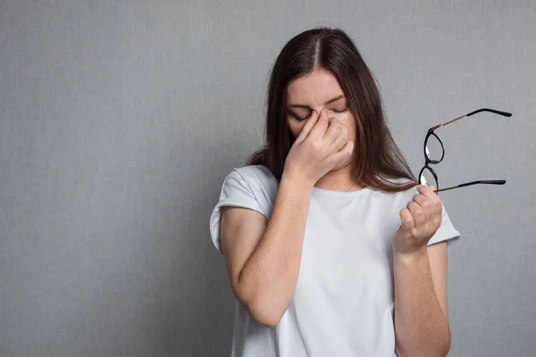 Mujer cansada se quita las gafas de vista y frota los ojos —  Fotos de Stock