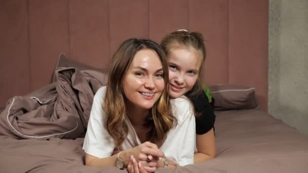 Moeder en tiener dochter veel plezier liggend op bed thuis — Stockvideo