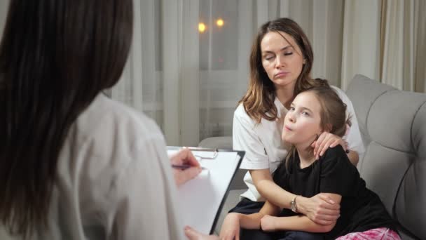 Moeder luistert naar arts voorschrijven van medicijnen voor dochter — Stockvideo