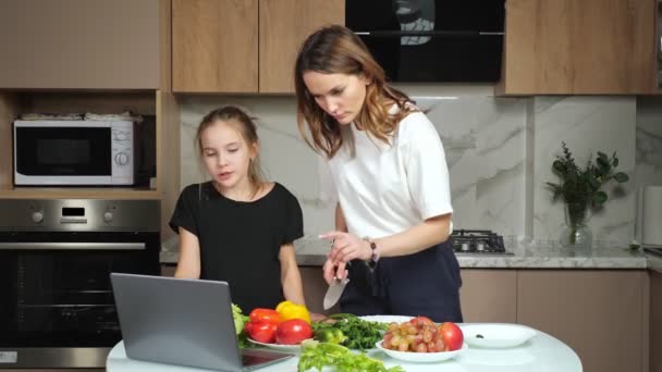 Mère et fille adolescente regarder la recette de salade dans un ordinateur portable — Video