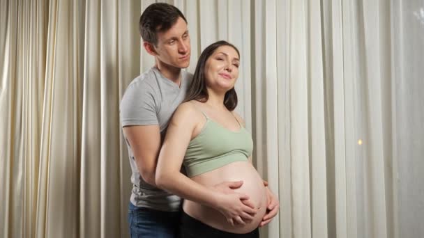 Married couple hugs caressing pregnant bare belly with love — Stock Video