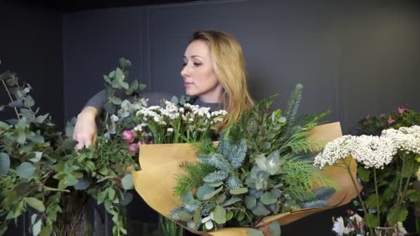 Florist arranges flowers and twigs to make spring bouquet — Vídeos de Stock