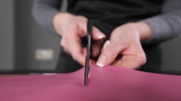 Toko bunga memotong kertas pembungkus merah muda untuk karangan bunga dengan gunting — Stok Video