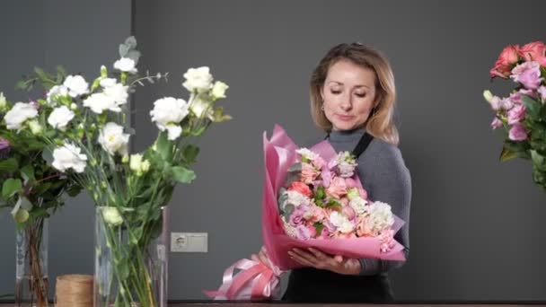Dumny kwiaciarnia blondynka kobieta trzyma składa kwiat bukiet — Wideo stockowe