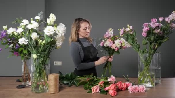 Bloemist vrouw componeert elegant boeket met kleurrijke bloemen — Stockvideo