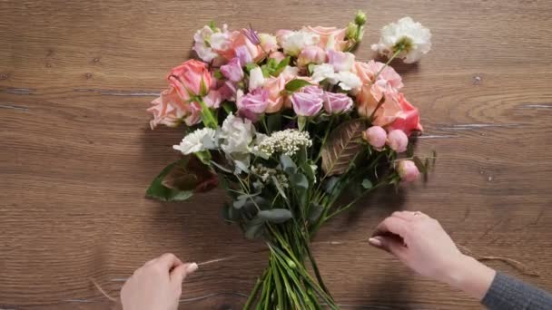 Buquê de laços florista com corda floral flexível fina na mesa — Vídeo de Stock