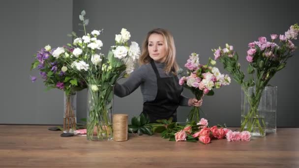 Kwiaciarnia kobieta komponuje elegancki bukiet z kolorowych kwiatów — Wideo stockowe