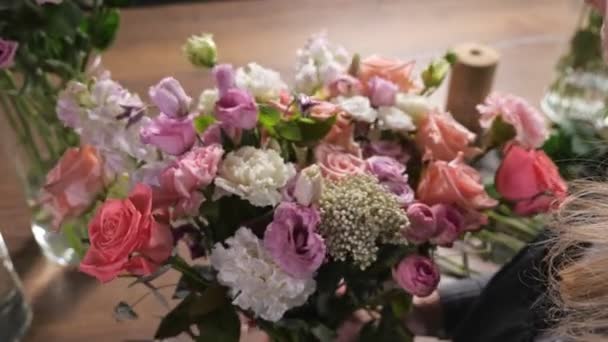 花屋の女性がフラワーショップで新鮮な春の花束を手配します — ストック動画