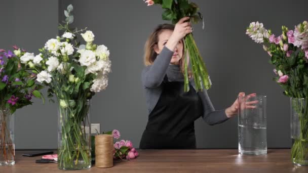 Blondynka kwiaciarnia bierze różowe róże, aby romantyczny bukiet — Wideo stockowe