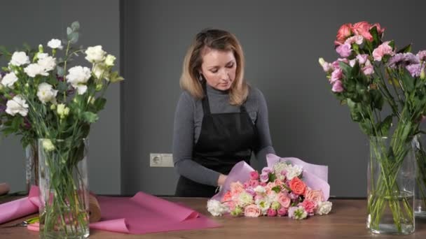 Kwiaciarnia kobieta sprawia, że elegancki bukiet ślubny z róż — Wideo stockowe