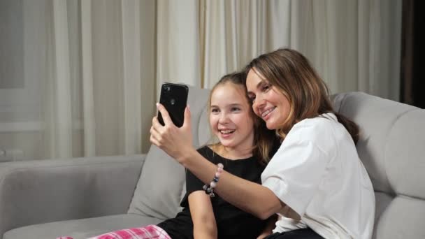 Mother and teen daughter talk on videocall sitting at home — Stock Video