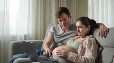 Karı koca gelecekteki bebek kucaklaşmaları için internetten alışveriş yapıyorlar.