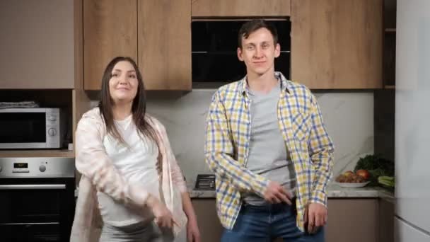 Young future parents dance together in kitchen smiling — Stock Video