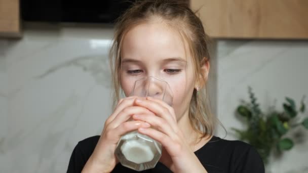 Adolescente chica bebe leche fresca en casa — Vídeo de stock