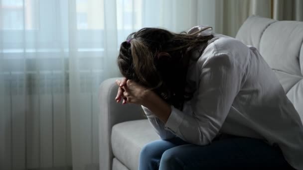 Η καταθλιπτική ανάπηρη γυναίκα νιώθει άσχημα που κάθεται στον καναπέ στο σπίτι — Αρχείο Βίντεο