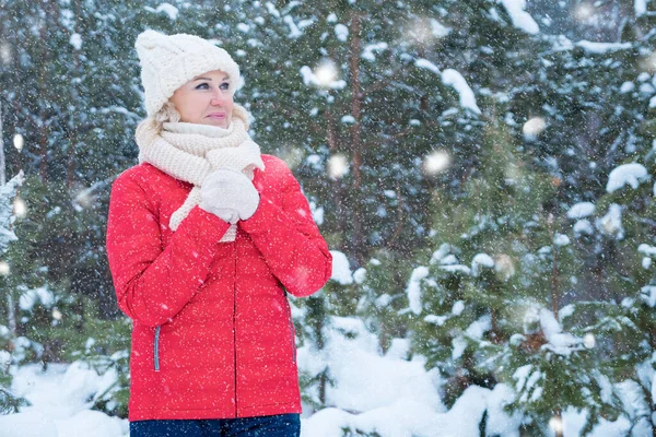 暖かい服のブロンドの女性は雪の冬の森の中に立つ — ストック写真