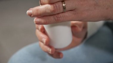 Yaşlı kadın, sağlığını korumak için paketten vitamin alıyor.