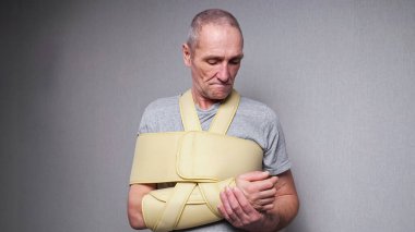 Sabitleyici bandajlı son sınıf öğrencisi parmaklarını ve eklemlerini kontrol ediyor.