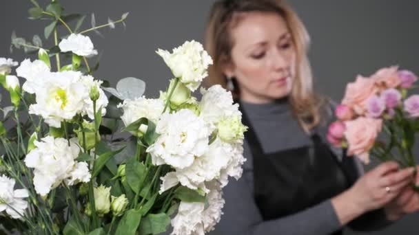 Ανθοπωλείο οργανώνει ρομαντικό μπουκέτο λουλουδιών με φρέσκα τριαντάφυλλα — Αρχείο Βίντεο