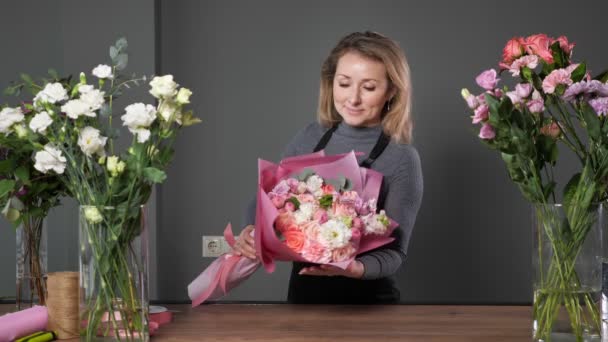 Orgullosa florista rubia mujer sostiene compuesto ramo de flores — Vídeos de Stock