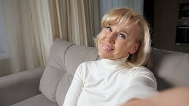 Donna matura con i capelli biondi prende selfie e sorrisi — Video Stock