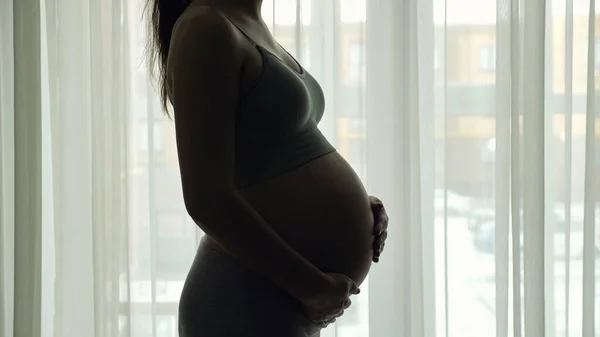 Femme enceinte silhouette en vêtements de sport coups gros ventre — Photo