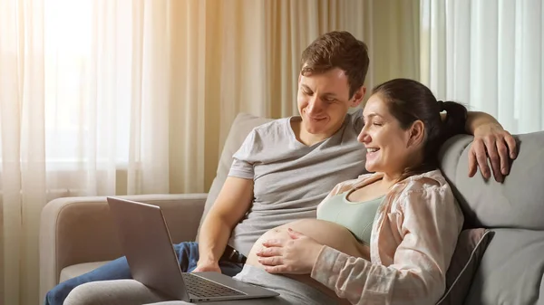 Mari et femme faire des achats en ligne pour le futur bébé câlin — Photo