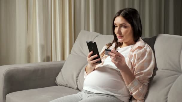 Brunett gravid kvinna betalar för online shopping via telefon — Stockvideo