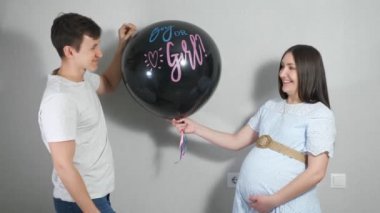 Genç ebeveynler doğmamış çocuklarının cinsiyetini mavi konfetiyle balon patlatarak öğrenirler.