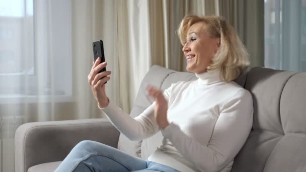 Зрелая женщина общается через видеокамеру с помощью смартфона — стоковое видео