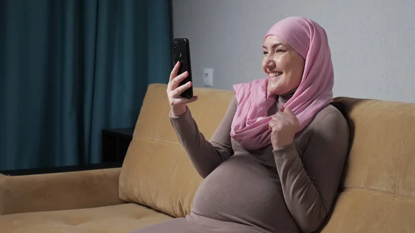 Беременная мусульманка обнаруживает хорошие новости, разговаривая через видеокассету — стоковое фото
