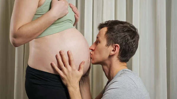 L'homme caresse et écoute le bébé à naître dans l'estomac de sa femme — Photo