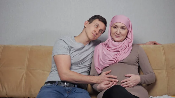 Muslimische Mutter und Vater streicheln Schwangerschaftsbauch lächelnd — Stockfoto