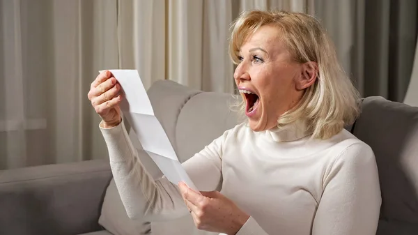 Vrouw van middelbare leeftijd krijgt gelukkig na ontvangst van erfenis Stockfoto