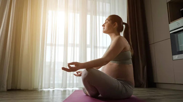 Donna incinta con grande pancia nuda medita sul tappetino yoga — Foto Stock