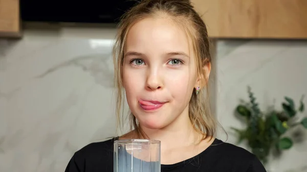 Teen girl drinks fresh milk licking white mustache at home — Stock Photo, Image