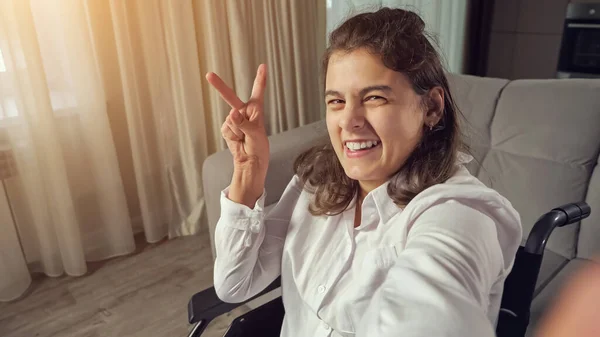 Behinderte Frau macht Finger Victory-Zeichen lächelt in die Kamera — Stockfoto