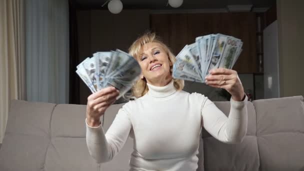 Middle aged woman tosses bills of pension in air of room — Stock Video