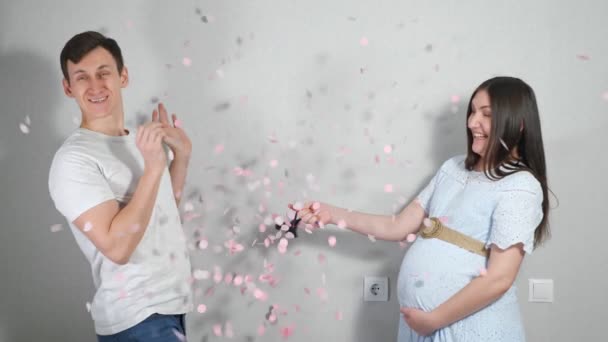 Junge Eltern erfahren das Geschlecht ihres ungeborenen Kindes, indem sie einen Luftballon mit rosa Konfetti aufsteigen lassen — Stockvideo