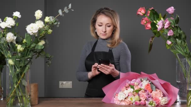 Floristería acepta pedidos de ramos de flores a través del teléfono móvil — Vídeos de Stock