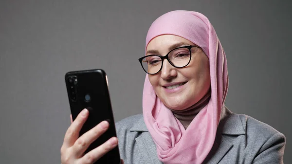 Muselman kvinna i hijab surfa internet sociala medier med leende — Stockfoto