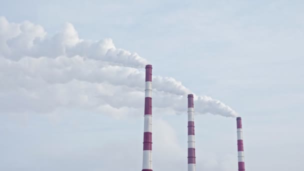 Белый дым из труб тепловой электростанции против голубого неба — стоковое видео