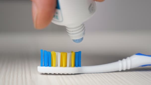 Van dichtbij bekijken van tandpasta met tandenborstel — Stockvideo